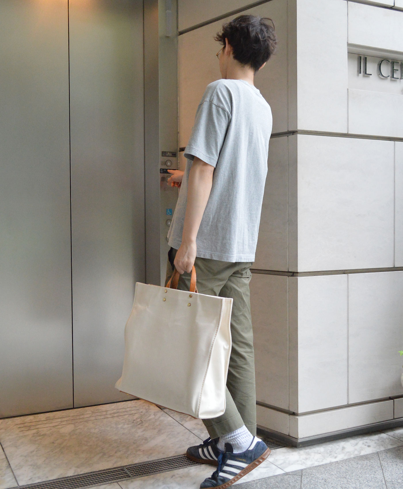 エレベーターに乗る西邑氏