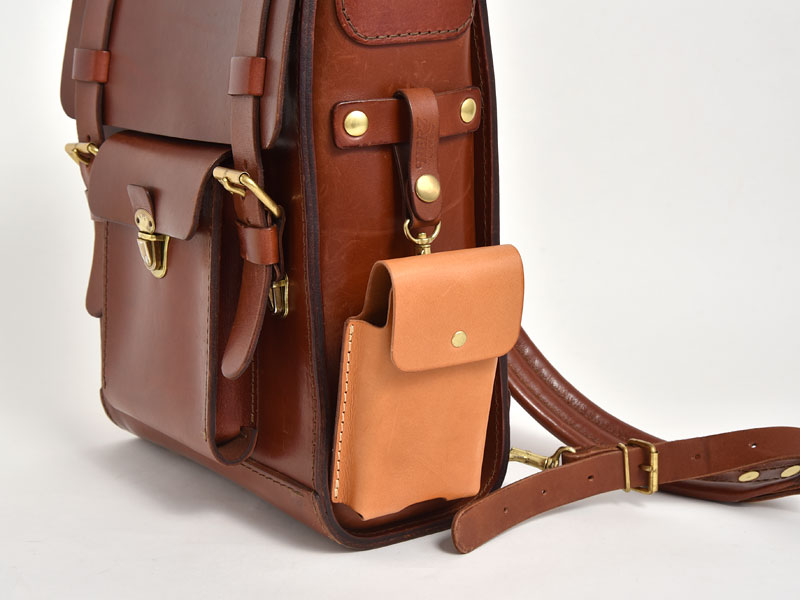 マルチスマホケース(KM-1)革色キャメルを鞄の側面に吊るした様子