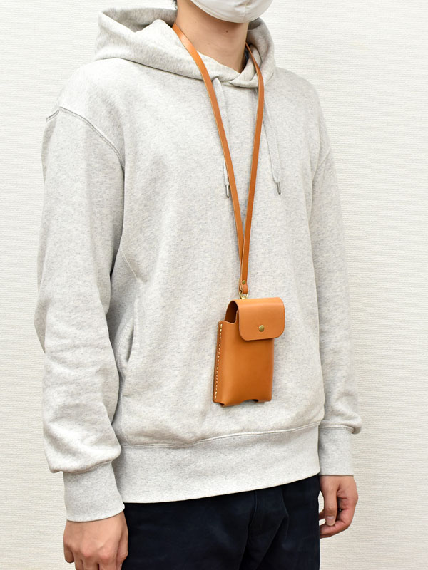 マルチスマホケース(KM-1)革色キャメルを首から下げた様子