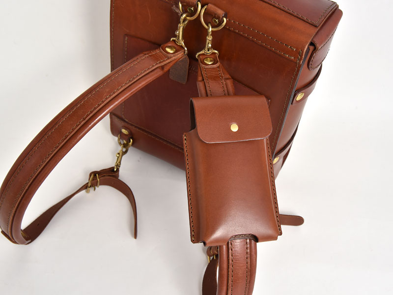 マルチスマホケース(KM-1)革色チョコをリュックストラップに取り付けた様子